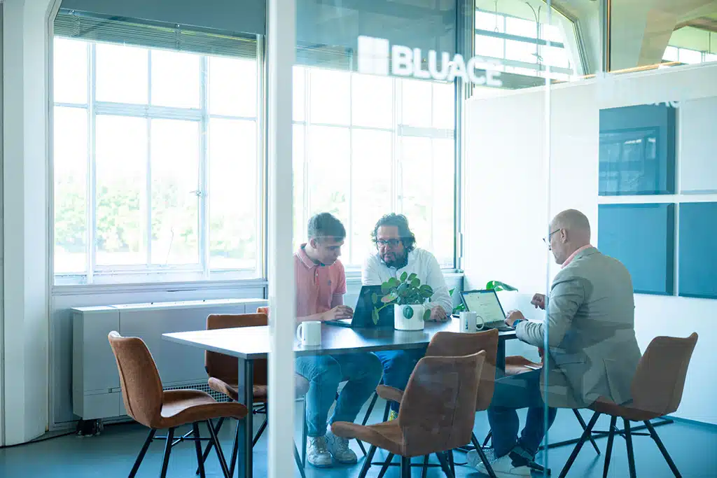 Een foto van medewerkers van Bluace aan het werk in de vergaderzaal