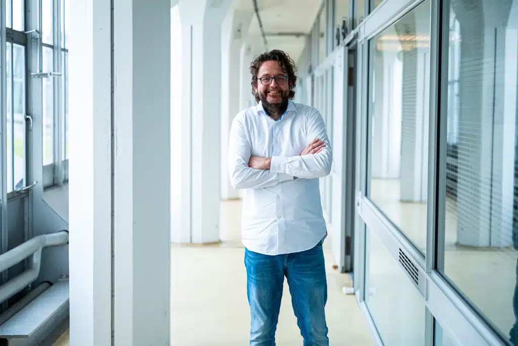 Een foto van een medewerker van Bluace voor het kantoor van Bluace in de Van Nelle Fabriek