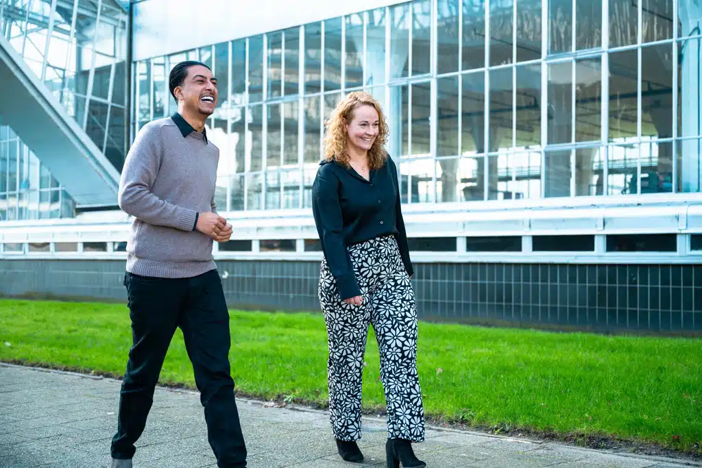 Een foto van twee medewerkers van Bluace buiten voor de Van Nelle Fabriek die lopen