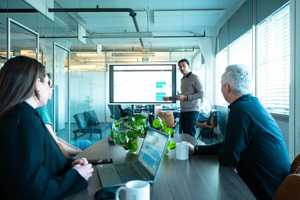 Een foto van medewerkers van Bluace in de vergaderzaal tijdens een presentatie waarin Business Central te zien is