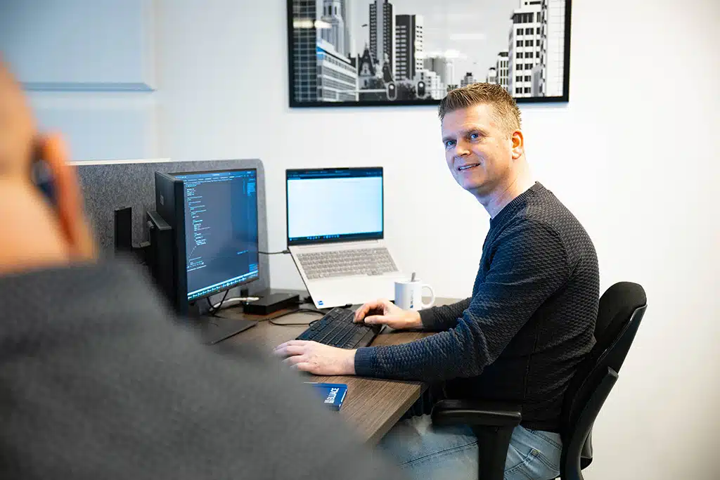 Een foto van een medewerker in het kantoor van Bluace achter een computer